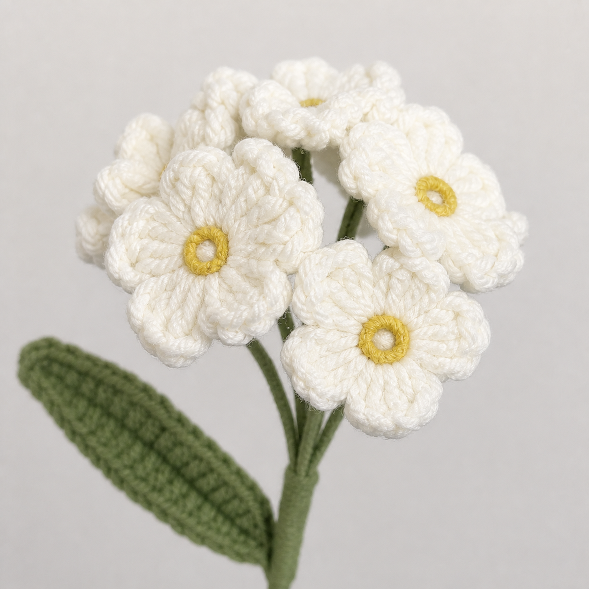 Close-up detail of ivory crochet forget-me-not with yellow flower centers