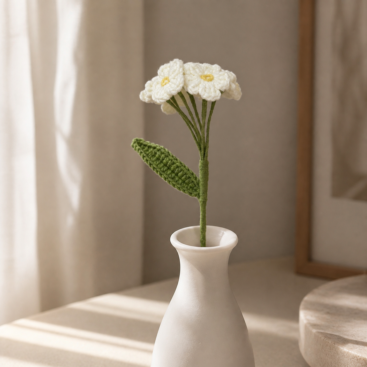 Handmade ivory crochet forget-me-not displayed in a white vase